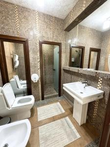 a bathroom with a toilet and a sink at Seoul Hotel in Shymkent