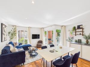 a living room with a table and blue chairs at Westminster Residences by Apt in London