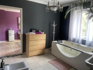 a bathroom with a large tub and a sink at Gemütlicher Oase mit eigenen Bad in Zentrale, jedoch ruhige Lage in Mönchengladbach
