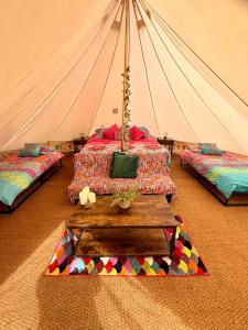 a tent room with two beds and a table at River View Glamping in Llandovery