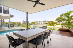 a large dining room table with chairs and a ceiling fan at Bluewater Oasis - Stay 4 Pay 3 in Gold Coast