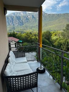 a balcony with two chairs and a view of mountains at Lovor apartmani in Zelenika