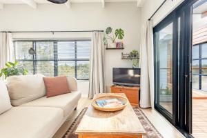 a living room with a couch and a table at Chapmans Corner Studio in Noordhoek