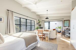 a bedroom with a bed and a desk and a table at Chapmans Corner Studio in Noordhoek