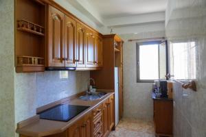 a kitchen with wooden cabinets and a sink and a window at Casa Argelio in Alojera