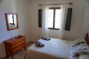 a bedroom with a bed and a dresser and a window at Casa Argelio in Alojera