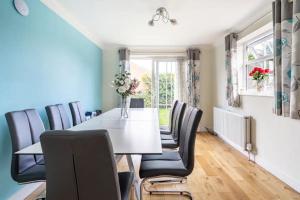 a dining room with a white table and black chairs at Bright Double Room with Shared Bathroom in Luton +16 photos