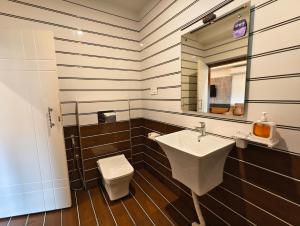 a bathroom with a sink and a toilet and a mirror at Laalis crest Coorg Madikeri in Madikeri +69 photos