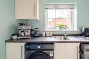 a kitchen with a counter top with a stove and a sink at Bright Double Room with Shared Bathroom in Luton