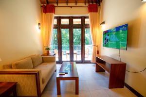 a living room with a couch and a tv at Riverdale lagoon villas in Aluthgama