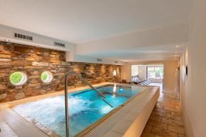 a hot tub in a room with a stone wall at Hotel Elisabeth in Schoppernau