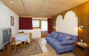 a living room with a blue couch and a table at Bauernhof Kuen in Längenfeld