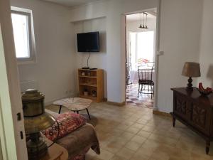 a living room with a couch and a tv at Le Refuge du Phare in Saint-Vivien-de-Médoc