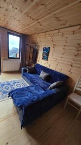 a large blue bed in a room with a wooden wall at Elia Hut Kazbegi in Kazbegi
