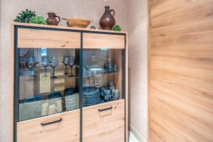 a glass cabinet with plates and bowls on it at Land Leben Wohnung 1 in Erkelenz