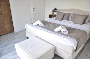 a bedroom with a large white bed with towels on it at Villa Saraj with Swimming Pool & Jacuzzi near Sarajevo in Sarajevo
