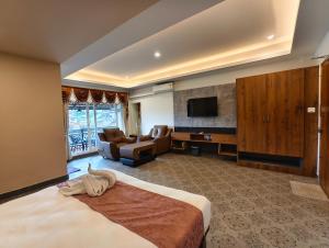 a hotel room with a bed and a living room at Laalis crest Coorg Madikeri in Madikeri