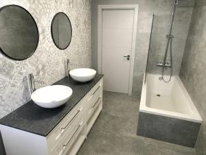 a bathroom with two sinks and a shower and a tub at Three Cities Haven in Taʼ Penza