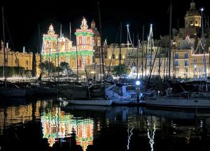 a group of boats docked in a marina at night at Three Cities Haven in Taʼ Penza