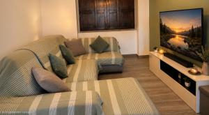 a living room with a couch and a flat screen tv at Three Cities Haven in Taʼ Penza