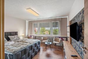 a bedroom with a large bed and a television at Land Leben Wohnung 1 in Erkelenz