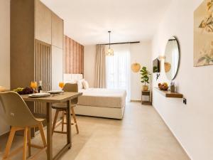 a hotel room with a bed and a table and a dining room at AVENA Suites in Kato Gouves +150 photos