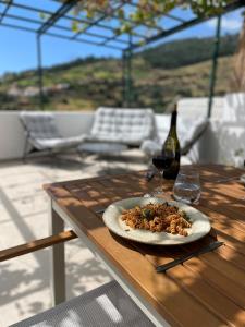 a plate of food on a table with a bottle of wine at Calheta Suites - Vinha & Jardim - Adults-only suites met hottub & zeezicht in Calheta