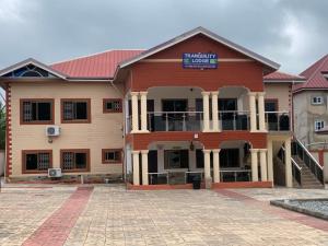 a large red building with a sign on it at Tranquility Lodge in Abrekuma
