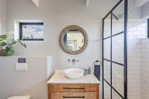 a bathroom with a sink and a mirror at Chapmans Corner Studio in Noordhoek +36 photos