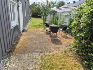 a patio with a table and chairs next to a house at Den fräscha lägenheten in Ängelholm