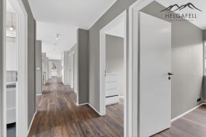 a hallway with white doors and wood floors at Kleppjárnsbraut in Kleppjárnsreykir