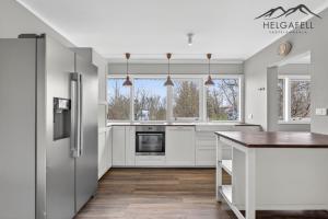 a kitchen with white cabinets and a refrigerator at Kleppjárnsbraut in Kleppjárnsreykir