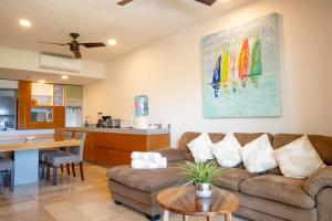 a living room with a couch and a kitchen at Costa Brava Apartments I Ocean Front in Puerto Aventuras