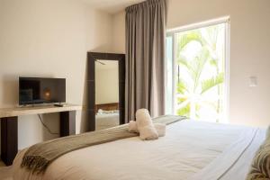 a bedroom with a bed with a large window at Costa Brava Apartments I Ocean Front in Puerto Aventuras