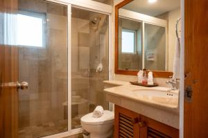 a bathroom with a shower and a toilet and a sink at Costa Brava Apartments I Ocean Front in Puerto Aventuras +35 photos