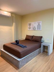 a large bed in a room with a table at The 10 Club Hostel & Tiny Villas in Thong Sala