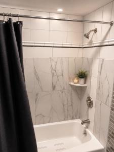 a bathroom with a white tub and marble tiles at Chateau Royale Inn in Lake Geneva +12 photos