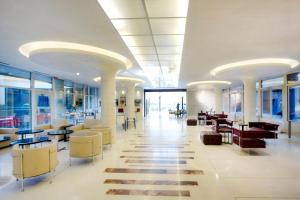 un hall avec des tables et des chaises dans un bâtiment dans l'établissement Art Hotel Navigli, à Milan