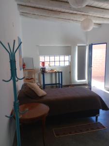 a bedroom with a bed and a table in it at Cabañas don Julio in Maimará +15 photos