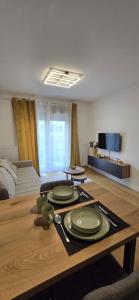 a living room with a table with plates on it at Apartman Raj VV sa garazom Vrnjačka Banja in Vrnjci