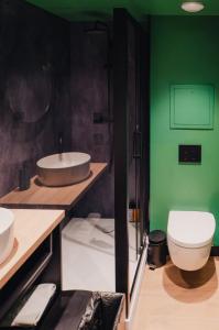 a bathroom with a sink and a toilet and green walls at Cowool Créteil in Créteil