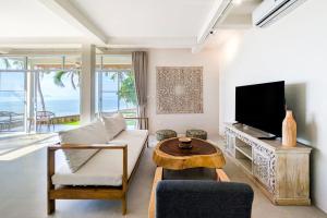 a living room with a couch and a tv at Happy Home kpg in Ko Phangan