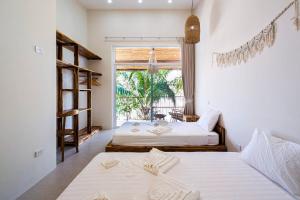 two beds in a room with a window at Happy Home kpg in Ko Phangan +48 photos