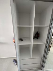 a white closet with white shelves in a room at New Luxury Studio In Caesar Resort & Spa in Dherinia