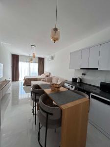 a kitchen and living room with a table and chairs at New Luxury Studio In Caesar Resort & Spa in Dherinia