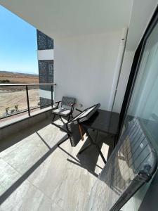 a balcony with two chairs and a table and a window at New Luxury Studio In Caesar Resort & Spa in Dherinia