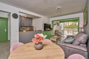 a living room with a table with a vase of flowers at Casita Helena in Torrox