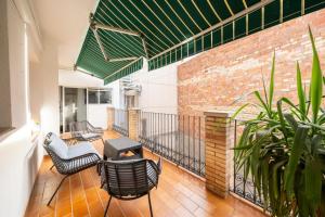 a balcony with furniture and a brick wall at Classic Can Jeroni in Figueres