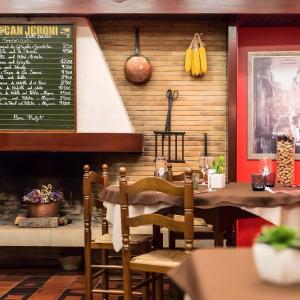 a restaurant with a table and a menu on the wall at Classic Can Jeroni in Figueres
