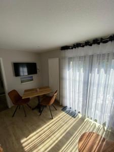 a room with a desk and a television and curtains at Ferienwohnung "Auszeit" in Dobra